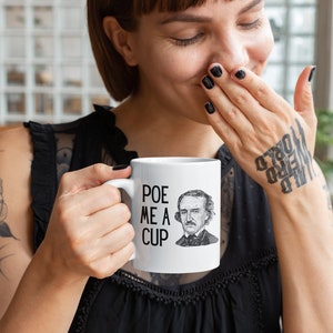 Può includere: Tazza in ceramica bianca con un'illustrazione in bianco e nero di Edgar Allan Poe e il testo "POE ME A CUP".
