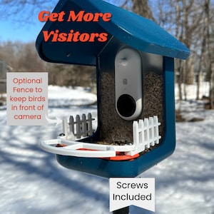 以下が含まれることがあります： 青い鳥の餌箱に白いフェンスと白いカメラが取り付けられています。餌箱の下には白いトレイがあり、上には「Get More Visitors」という文字が書かれています。下には「Screws Included」という文字が書かれています。左側に「Optional Fence to keep birds in front of camera」という文字が書かれています。