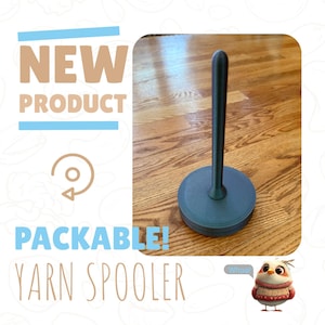 May include: A dark blue yarn spooler with a round base and a tall, slender post. The spooler is made of plastic and has a smooth, matte finish. The text "Packable! Yarn Spooler" is visible in the image.