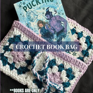 May include: A handmade crochet book bag in a granny square pattern. The bag features a combination of white, teal, and lavender yarn. The bag holds a book with the title "Pucking" on the cover. The text "CROCHET BOOK BAG" and "**BOOKS ARE ONLY FOR DISPLAY:-)" are also visible.