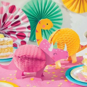 Op de afbeelding: Roze, gele en groene papieren dinosaurusdecoraties voor een feestje. De dinosaurussen zijn gemaakt van honingraatpapier en hebben een 3D-effect.