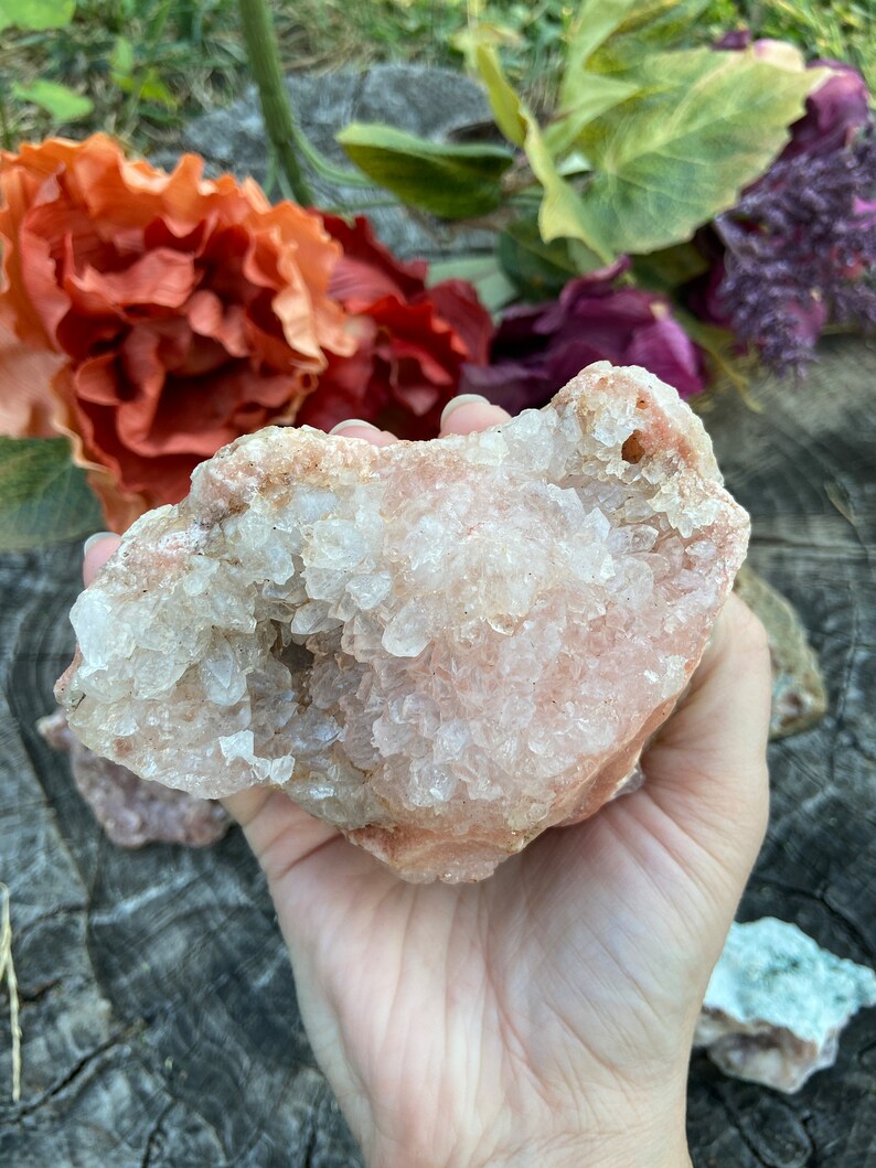 May include: A large, pink, and white crystal cluster with a rough, natural texture. The crystal is covered in small, white crystals.