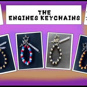 May include: Four beaded keychains labelled THE ENGINES KEYCHAINS. Each features a star charm, a lightning bolt charm, and a strand of letter beads spelling names like ELECTRA and RUSTY. The beads are arranged in various colour patterns including black and gold, red white and blue, and black and silver.