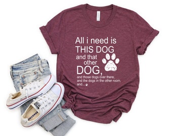May include: A maroon t-shirt with the text "All I need is THIS DOG and that other DOG, and those dogs over there, and the dogs in the other room, and..." with a white paw print graphic.