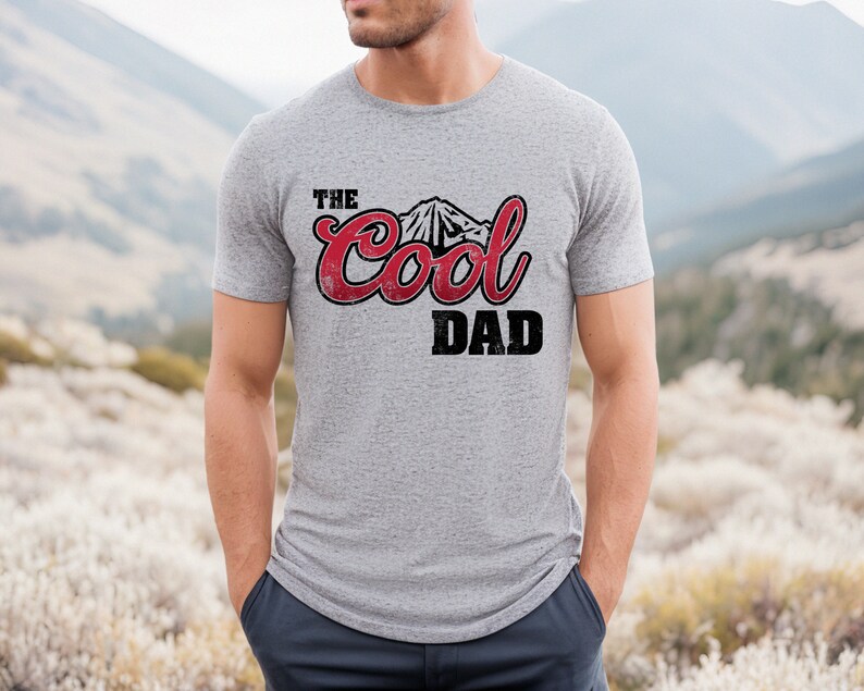 May include: A gray t-shirt with a red and black graphic that says "The Cool Dad" with a mountain silhouette.