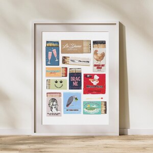 May include: A framed print featuring various matchbox designs. The matchboxes have unique graphics and text, including "La Dame," a champagne toast, a knife, a chicken, "Reasonably Sassy," "Drag Me," a pizza box, a parrot, and "Cayman Islands."