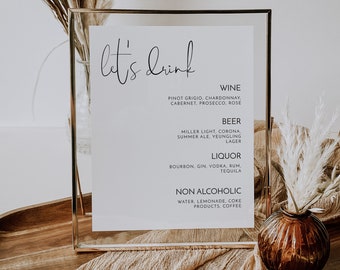 May include: A gold-framed sign with the text "let's drink" in black cursive font. The sign lists different types of alcoholic and non-alcoholic beverages, including wine, beer, liquor, water, lemonade, coke, and coffee.
