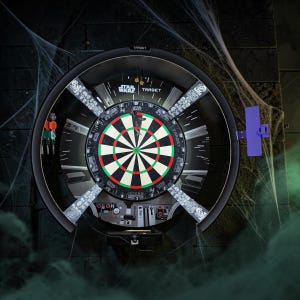 以下が含まれることがあります： 黒いフレームのスターウォーズをテーマにしたダーツボード。赤、緑、白のセグメントを備えたクラシックなダーツボードのデザインです。ボードはクモの巣のある暗い壁に取り付けられています。