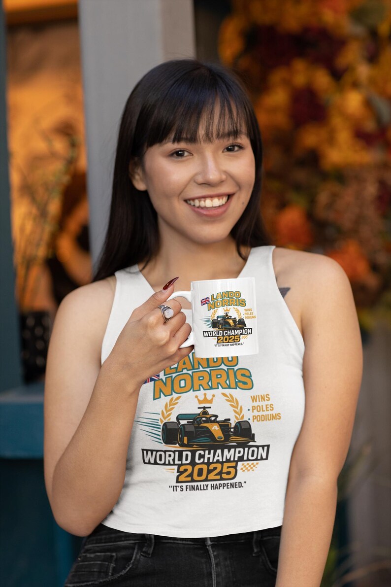 Op de afbeelding: Witte keramische mok met een Formule 1-raceauto-ontwerp en de tekst "LANDO NORRIS WORLD CHAMPION 2025". De mok bevat ook de tekst "WINS, POLES, PODIUMS" en "IT'S FINALLY HAPPENED."