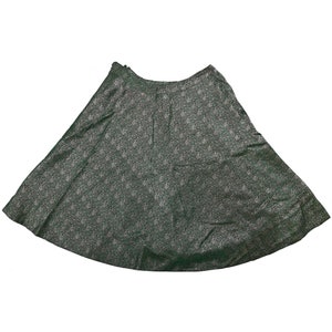 May include: A dark green skirt with a white floral pattern. The skirt is a-line and has a high waist.
