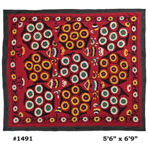 K&ouml;nnte beinhalten: Ein roter Wandbehang aus Stoff mit schwarzem Rand und einem floralen Muster in Gelb-, Gr&uuml;n-, Wei&szlig;- und Rosat&ouml;nen. Der Stoff ist mit einem sich wiederholenden Muster aus Blumen und Bl&auml;ttern bestickt. Der Wandbehang misst 1,68 m x 2,06 m.
