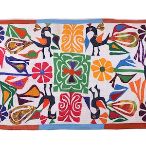 May include: A colourful patchwork quilt with a white background featuring a symmetrical design of peacocks, flowers, and geometric shapes. The quilt is made from a variety of fabrics in shades of red, orange, yellow, green, blue, purple, and brown.