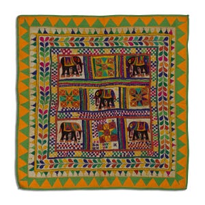 Può includere: Un arazzo da parete quadrato in tessuto colorato con un motivo geometrico di elefanti e stelle ricamate. Il tessuto è circondato da un bordo verde e arancione.