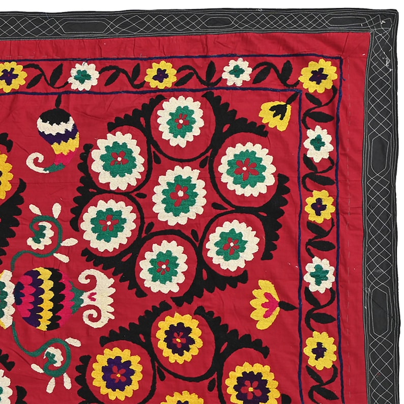 K&ouml;nnte beinhalten: Ein roter Wandbehang aus Stoff mit schwarzem Rand und aufwendigen Stickereien mit bunten Blumenmustern. Die Stickerei umfasst eine Vielzahl von Blumen, Bl&auml;ttern und anderen Motiven.