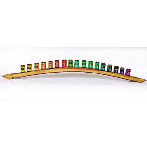 May include: A wooden wine barrel stave display stand with 20 small glass bottles filled with colourful liquids. The bottles are arranged in a rainbow pattern.