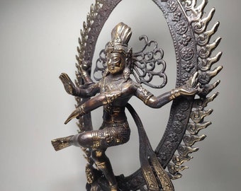 May include: A bronze statue of a Hindu deity, Shiva, in the Nataraja pose, dancing on a demon. The statue is surrounded by a circular halo with intricate details.
