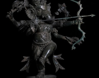 Op de afbeelding: Een donkergroen bronzen beeld van Ganesha, de hindoeïstische god van wijsheid en voorspoed, die een boog en pijl vasthoudt. Het beeld is ingewikkeld gedetailleerd en heeft een traditioneel Indiaas ontwerp.