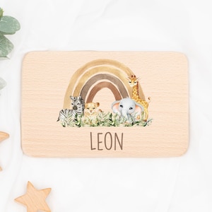 May include: A wooden plaque with a rainbow and safari animals, including a zebra, lion, elephant, and giraffe. The plaque has the name "LEON" written on it.