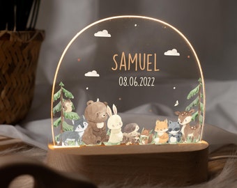 May include: A wooden night light with a clear acrylic dome featuring a woodland scene with animals like a bear, rabbit, fox, and deer. The dome also includes the name "SAMUEL" and the date "08.06.2022".