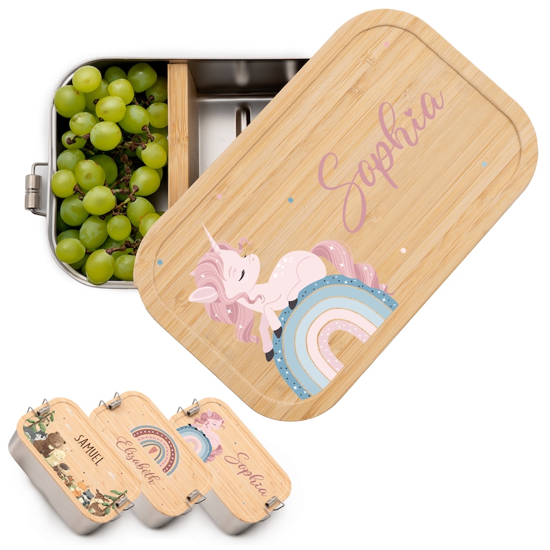May include: A set of three stainless steel lunchboxes with bamboo lids. Each lid features a different design: a unicorn on a rainbow, a forest scene, and a rainbow with stars. The lids are personalized with the names "Sophia", "Elisabeth", and "Samuel".