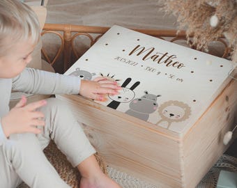 May include: A light-colored wooden box with a decorative lid featuring animal illustrations and the name "Matheo". The lid also includes the date 20.05.2022, weight 3500 g, and height 50 cm.