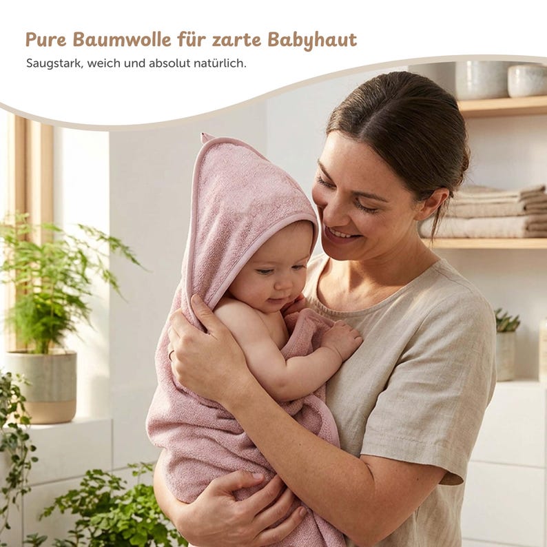 K&ouml;nnte beinhalten: Ein Baby, eingewickelt in ein weiches, rosa Kapuzenhandtuch, wird von einer Person gehalten. Das Handtuch besteht aus saugf&auml;higem Material. Der Text oben im Bild lautet: "Reine Baumwolle f&uuml;r zarte Babyhaut."