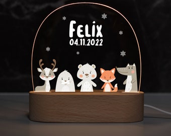 May include: A wooden night light with a clear acrylic dome featuring a reindeer, a polar bear, a fox, and a wolf. The dome is illuminated from the bottom and has the name "Felix" and the date "04.11.2022" printed on it.