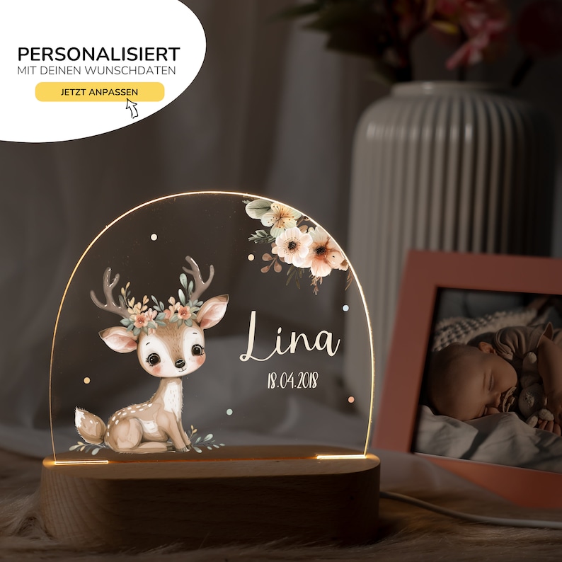 Op de afbeelding: Een gepersonaliseerd nachtlampje met een hert-illustratie, bloemmotieven en de naam "Lina" met de datum "18.04.2018".