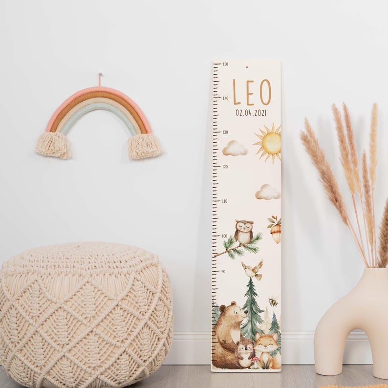May include: A wooden growth chart ruler featuring the name LEO, the date 02.04.2021, and illustrations of a sun, clouds, an owl, a bear, a fox, and pine trees. The chart includes measurement markings from 0 to 150 centimeters.