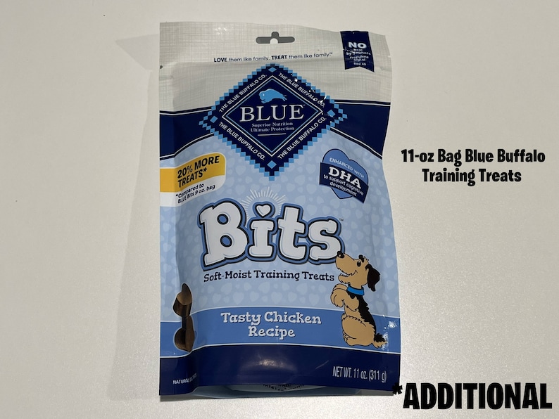 May include: An 11-ounce bag of Blue Buffalo Bits soft-moist training treats for dogs. The bag features a blue and white design with a picture of a dog and the text "Tasty Chicken Recipe".