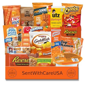 May include: An assortment of packaged snacks, including Chex Mix, Quaker oatmeal, popcorn, potato chips, and Cheetos. Other items include Goldfish crackers, Reese's peanut butter cups, and granola bars. The box is orange and has the text "Sent With Care USA".