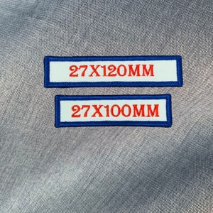May include: Two white fabric patches with blue borders and red text. The top patch reads "27X120MM" and the bottom patch reads "27X100MM".