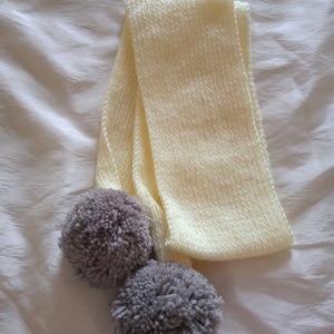 Hand knitted scarf with pompoms