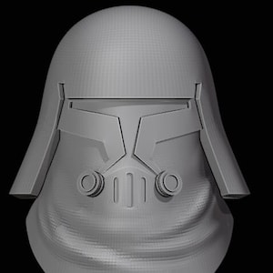 May include: A grey plastic helmet with a visor and a textured surface. The helmet has a design on the front with two round openings and a rectangular opening.
