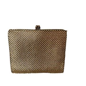 May include: A gold mesh clutch purse with a clasp closure.