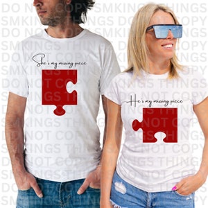 May include: Two white t-shirts with red puzzle pieces and the text "She's my missing piece" and "He's my missing piece".