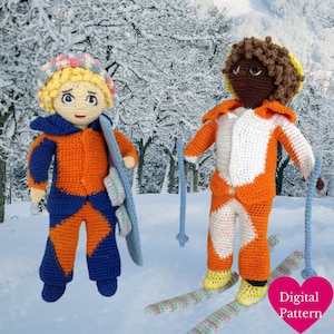 Puede incluir: Dos muñecas de crochet vestidas con trajes de esquí naranja y azul. Una muñeca sostiene un esquí azul y blanco. La otra muñeca sostiene dos bastones de esquí y está de pie sobre esquís con un patrón de rayas de colores.