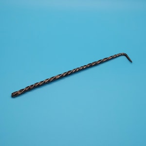May include: A twisted metal tool with a hooked end. The tool is black and has a rough, textured surface.