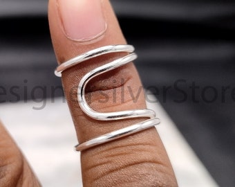 Op de afbeelding: Een zilveren ring met een uniek, golvend ontwerp. De ring is gemaakt van drie zilveren banden die met elkaar zijn verweven.