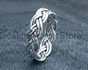 May include: A silver braided ring with a woven design.