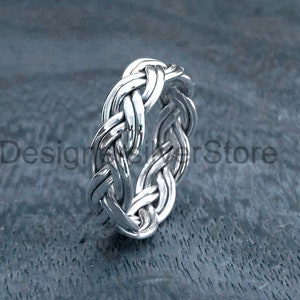 May include: A silver braided ring with a woven design.