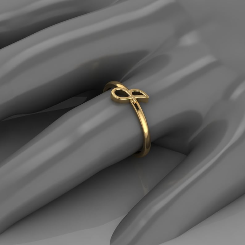 May include: A gold ring with a stylized letter 'P' design.