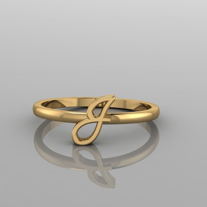 May include: A gold ring with a cursive letter J on the side.