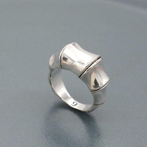 Może przedstawiać: Srebrny pierścionek z wzorem bambusa. Pierścionek jest rozmiaru 9.