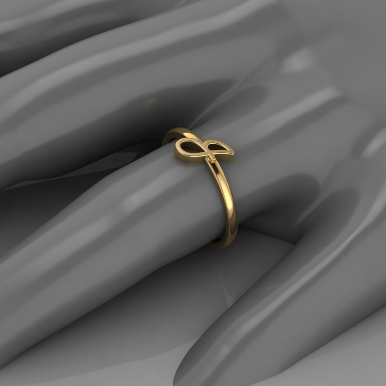 May include: A gold ring with a stylized letter 'P' design.