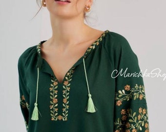 May include: Dark green blouse with floral embroidery on the sleeves and neckline. The blouse has a V-neck with tassels and the text "MarichkaShop" in the upper right corner.