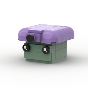 Könnte beinhalten: Eine kleine, grüne und violette Lego-Figur mit einem runden Kopf und schwarzen Augen. Die Figur trägt einen violetten Hut mit einem schwarzen Knopf oben drauf.