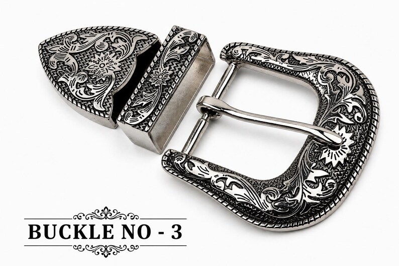 Op de afbeelding: Een zilverkleurige metalen riemgespset met een sierlijk gegraveerd bloemmotief op het frame van de gesp, een bijpassende rechthoekige lus en een puntig uiteinde. De tekst BUCKLE NO - 3 is in het zwart onderaan de afbeelding gedrukt.