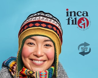 May include: A woman wearing a colorful knitted hat and scarf smiles at the camera. The hat has a yellow, green, red, and black pattern. The scarf has a similar pattern with blue accents. The background is a light blue.
