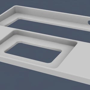 Puede incluir: Una bandeja rectangular gris claro con dos recortes rectangulares y un recorte cuadrado más pequeño. La bandeja tiene un borde elevado y un pequeño recorte de asa en un lado. El objeto está sobre un fondo azul.